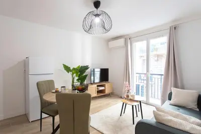 a kitchen and living room with a table and a couch at #58 Logement Clim & Balcon 5mins marche de la Mer in Nice