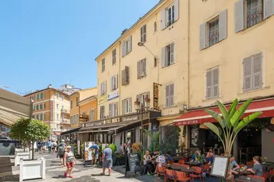 a group of people walking down a street with buildings at Nice Renting - 5bFRANCE - Luxurious Apartment Place Massena Promenade des Anglais in Nice