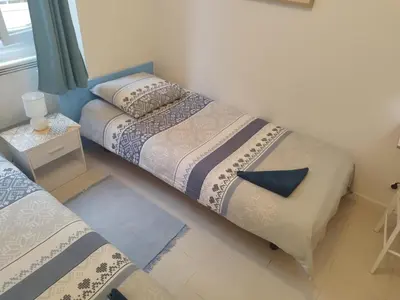two beds in a small room with a window at Private Room in Shared Apartment in the Center of Nice in Nice