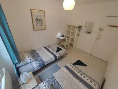 a small room with two beds and a table at Private Room in Shared Apartment in the Center of Nice in Nice