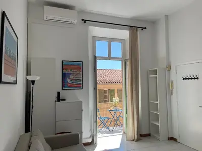 a living room with a door open to a patio at Le Bosio-studio avec vue mer in Nice