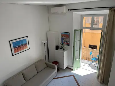 a living room with a couch and a sliding glass door at Le Bosio-studio avec vue mer in Nice
