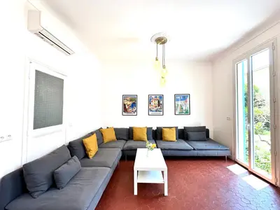 a living room with a blue couch and yellow pillows at Villa Lila in Nice