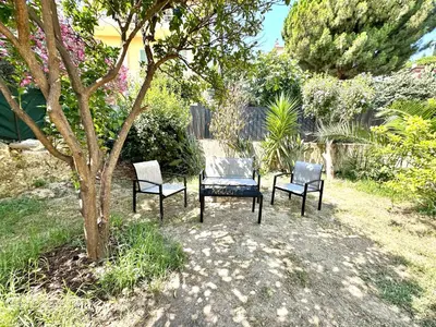 a group of three chairs sitting next to a tree at Villa Lila in Nice