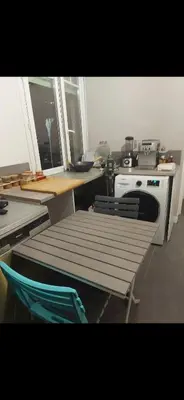 a kitchen with a table and a chair and a stove at appartement 10mn à pied plage promenade in Nice