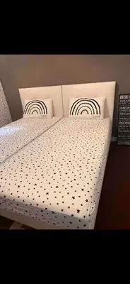 a bed with a white comforter and two pillows at appartement 10mn à pied plage promenade in Nice