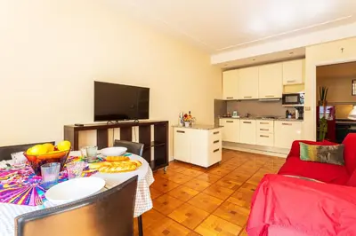 a living room with a table and a kitchen at LE CAPITOL 2 AP4421 By Riviera Holiday Homes in Nice