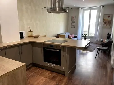 a kitchen with a counter top and a living room at Appart T3 Clim Hypercentre in Nice