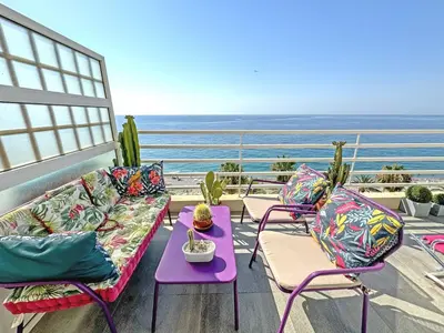 a balcony with a couch and chairs and the ocean at Sea Front Penthouse Cote d Azur in Nice