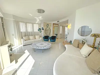a living room with a couch and a table at Sea Front Penthouse Cote d Azur in Nice