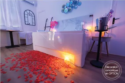a bathroom with a tub with red petals on the floor at Riviera Bliss in Nice