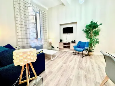 a living room with a chair and a television at ApartHotel Riviera - COCON DU MOULIN - Old Town Promenade des Anglais in Nice