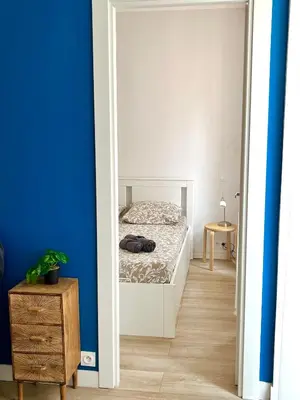 a bedroom with a bed and a blue wall at Center 2 min walk to beach quiet sunny balcony in Nice