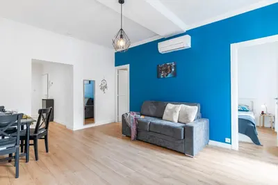 a living room with a couch and a blue wall at Center 2 min walk to beach quiet sunny balcony in Nice