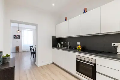 a kitchen with white cabinets and a dining room at Center 2 min walk to beach quiet sunny balcony in Nice