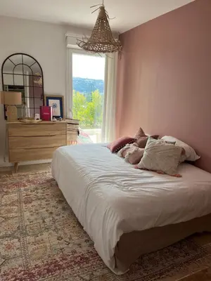a large bed in a bedroom with a window at Superbe appartement lumineux en rez de jardin in Saint-Laurent-du-Var