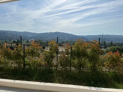 a white couch sitting on a balcony with a rug at Superbe appartement lumineux en rez de jardin in Saint-Laurent-du-Var
