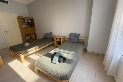 a room with two beds and a book shelf at Spacieux appartement climatisé centre Nice in Nice