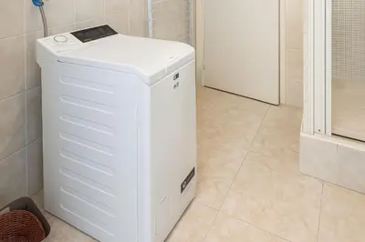 a white refrigerator in a bathroom with a floor at Spacieux appartement climatisé centre Nice in Nice