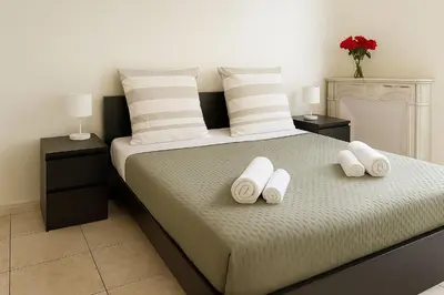 a bedroom with a bed with two white towels on it at Spacieux appartement climatisé centre Nice in Nice
