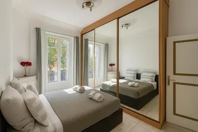 a bedroom with two beds and a large mirror at Spacieux appartement climatisé centre Nice in Nice