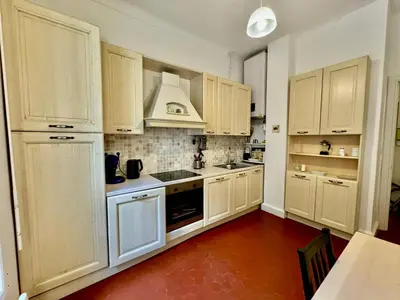 a kitchen with white cabinets and a stove top oven at 2P Moderne Riquier proche Port, Gare, Tramway in Nice