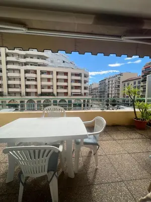a white table and chairs on a balcony with buildings at La Terrasse de Palais des Arts in Nice