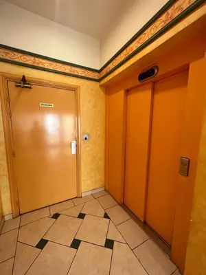 a hallway with an orange door and a tile floor at La Terrasse de Palais des Arts in Nice