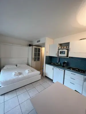 a bedroom with a bed and a kitchen with a microwave at La Terrasse de Palais des Arts in Nice