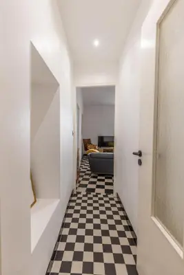 a hallway with a black and white checkered floor at Appartement de charme centre vieux village in Villefranche-sur-Mer
