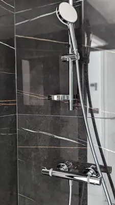 a shower with a mirror and a toothbrush at Olive Grove Retreat in La Trinité