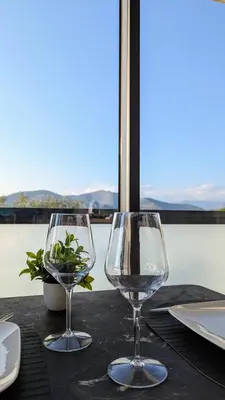 two wine glasses sitting on top of a table at Olive Grove Retreat in La Trinité