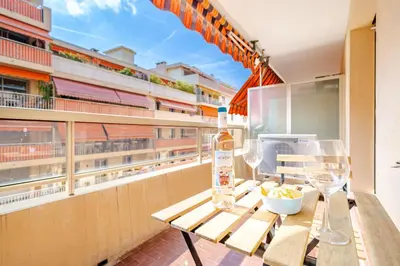 a table with a bottle of wine and glasses on a balcony at Near old town and apartment fully renovated in Nice
