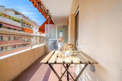 a table on a balcony with a bottle and a glass at Near old town and apartment fully renovated in Nice
