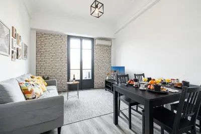 a living room with a table and a couch at MY CASA - OLIVETTO - Superb city center apartment with AC in Nice