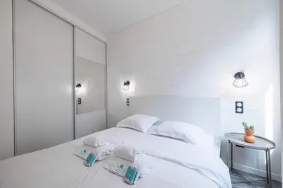 a white bedroom with a bed with towels on it at MY CASA - OLIVETTO - Superb city center apartment with AC in Nice