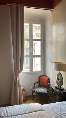 a bedroom with a bed and a chair and a window at Vera Nizza in Nice