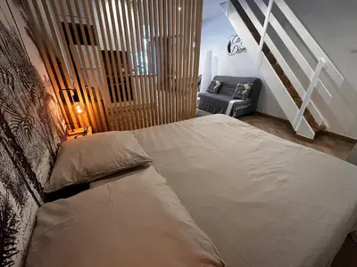 a bedroom with a large bed and a couch at Studio moderne climatisé avec coin nuit, proche mer et Hauts de Cagnes in Cagnes-sur-Mer