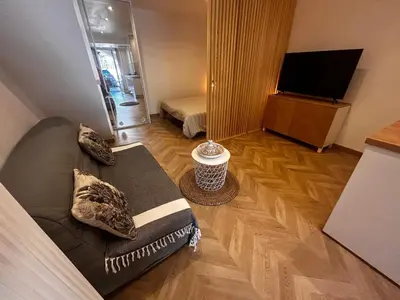 a living room with a couch and a television at Studio moderne climatisé avec coin nuit, proche mer et Hauts de Cagnes in Cagnes-sur-Mer