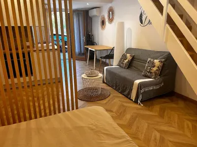 a living room with a couch and a table at Studio moderne climatisé avec coin nuit, proche mer et Hauts de Cagnes in Cagnes-sur-Mer