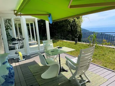 a patio with a table and chairs and an umbrella at Villa Riviera vue panoramique MER et NATURE in Èze