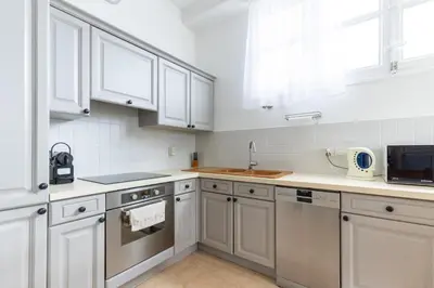 a kitchen with white cabinets and a sink at Happyfew La Promenade 53 in Nice