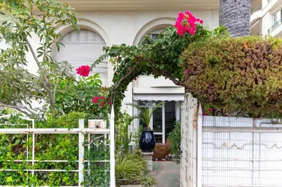 a white house with a white fence with pink flowers at Happyfew La Promenade 53 in Nice
