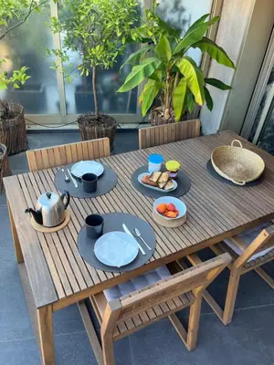 a wooden table with plates of food on it at Splendide penthouse au coeur de Nice in Nice