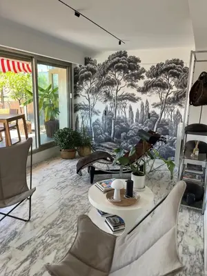 a living room with a mural of trees on the wall at Splendide penthouse au coeur de Nice in Nice