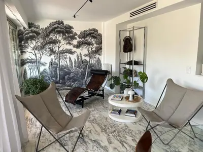 a living room with chairs and a mural of trees at Splendide penthouse au coeur de Nice in Nice
