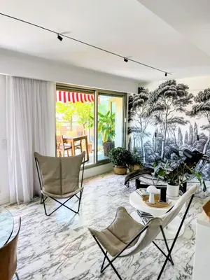 a living room with a mural of trees at Splendide penthouse au coeur de Nice in Nice