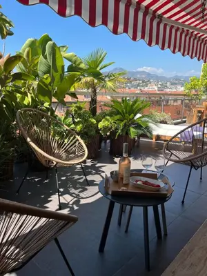 a patio with chairs and a table with a view at Splendide penthouse au coeur de Nice in Nice