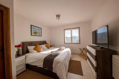 a bedroom with a large bed and a television at 06C-Villa for 8 persons with pool near Nice in Tourrette-Levens