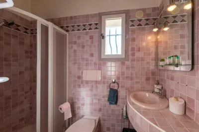 a pink tiled bathroom with a sink and a toilet at 06C-Villa for 8 persons with pool near Nice in Tourrette-Levens